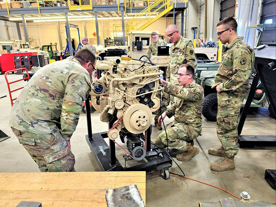 a group of men in military uniforms working on a machine