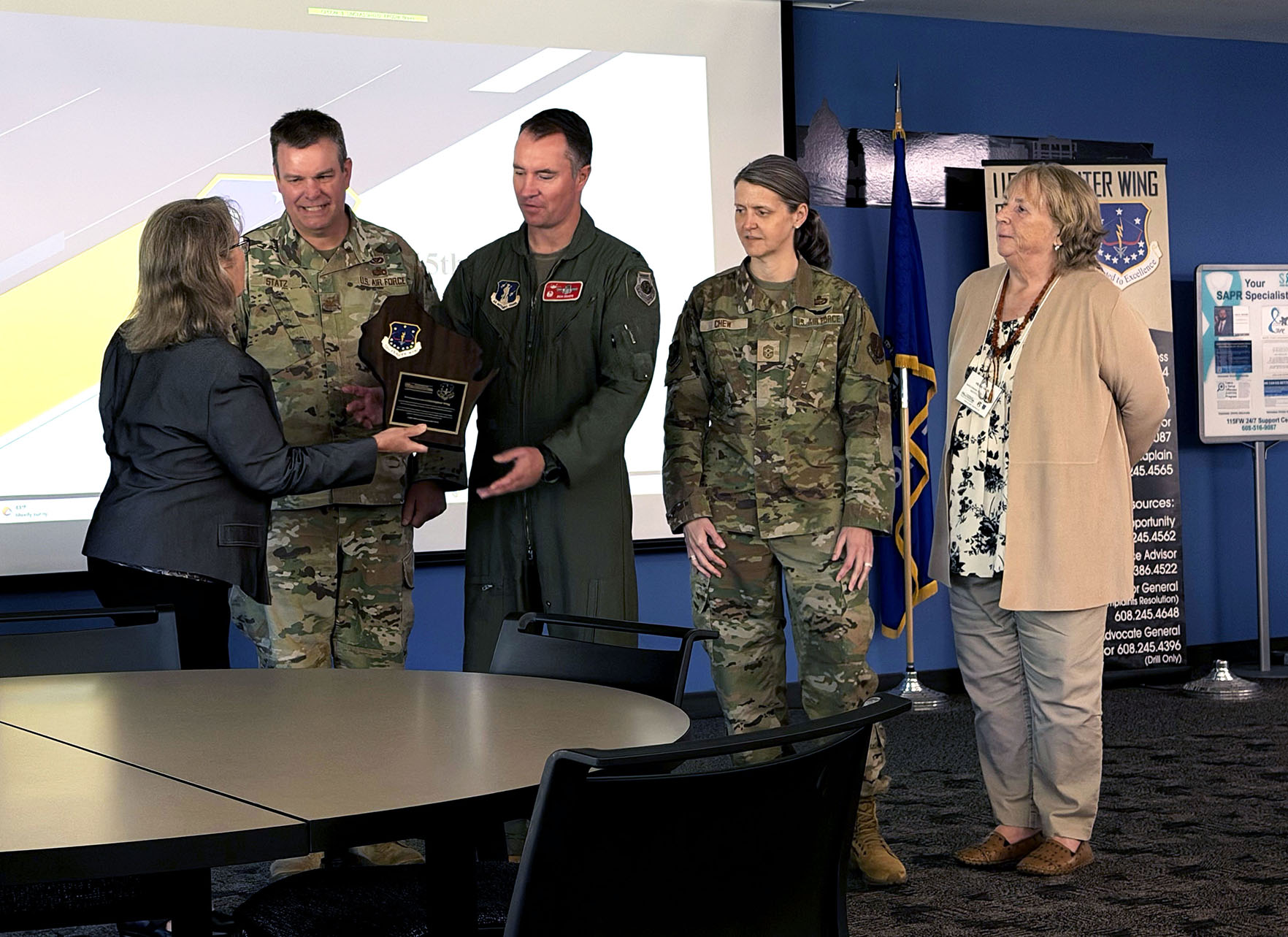 a group of people in military uniforms standing in front of a table