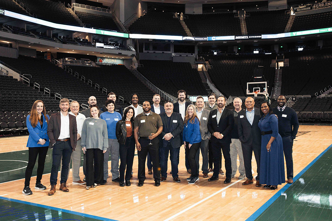 a group of people posing for a photo in a basketball court